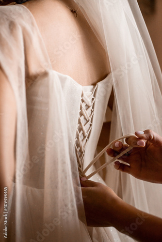girlfriend tying carset to bride