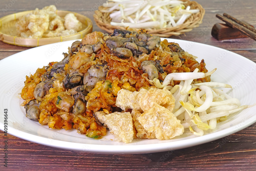 O Tao is a unique stir-fried dish made with Yam Oyster Omelettes mixed with battered taro, eggs, minced pork, garlic and spicy sauce, found only in Phuket Thailand. Phuket local street good