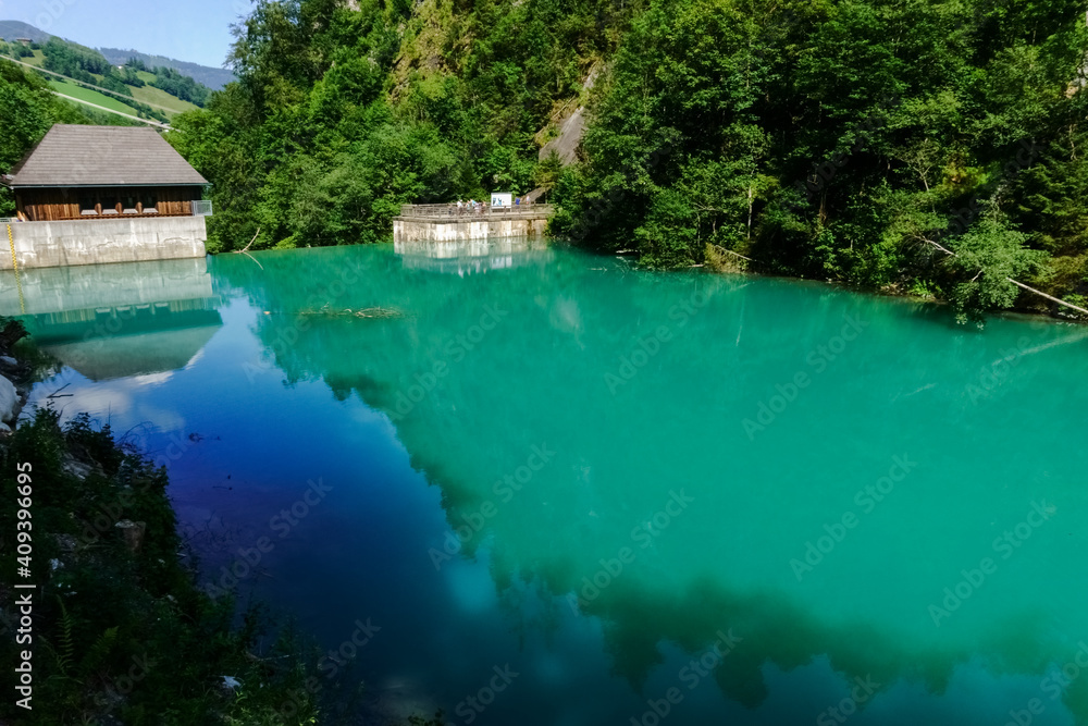 green turquoise water from a water reservoir with a dam wall