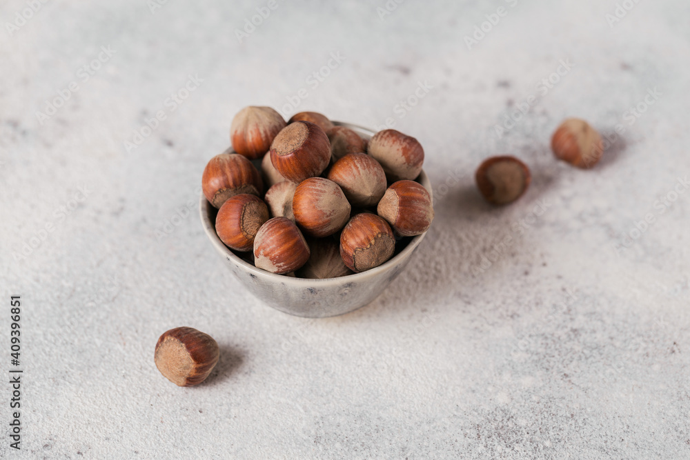 Pile of hazelnuts filbert in a bowl on a white background. Fresh nuts in their shells. Pile of hazelnuts filbert in a bowl on a white background. Fresh nuts in their shells.