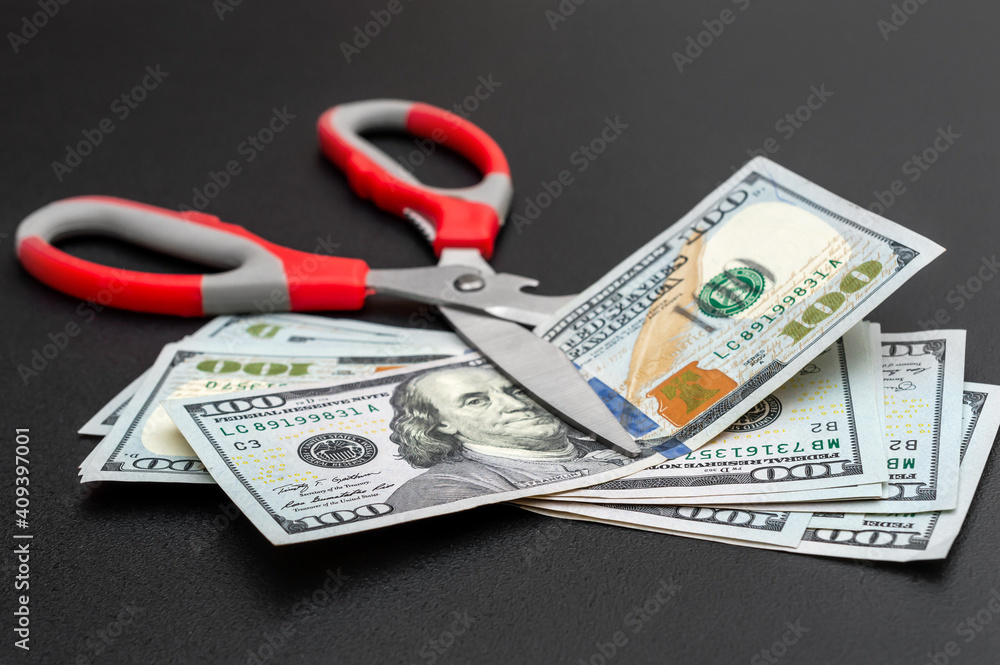 Scissors with money on black background. Close up. Business concept. Scissors with money on black background. Close up. Business concept.