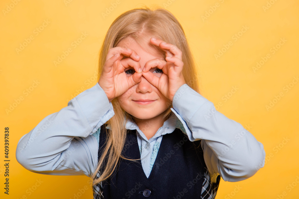 Girl in school uniform posing isolated on yellow background. Girl in school uniform posing isolated on yellow background.