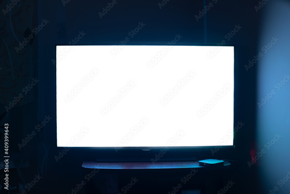 TV in a dark room with a white screen.