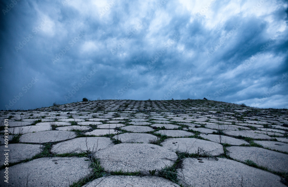Fototapeta premium Abandoned reservoir with dramatic dark clouds in the evening in Armenia, Kotayq