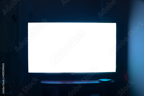 TV in a dark room with a white screen. 