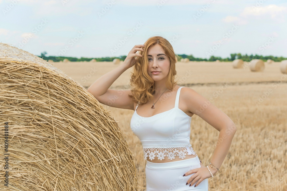 Natural modern plus size woman with full hips, pretty figure in white costume at field. Concept of femininity Natural modern plus size woman with full hips, pretty figure in white costume at field. Concept of femininity