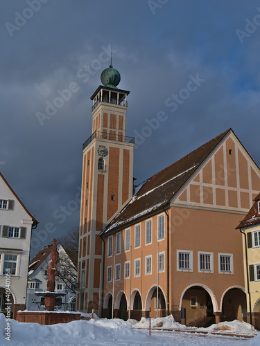 Beautiful portrait view of city hall of Freudenstadt, Black Forest, Germany located on snow-covered market place on sunny day in winter season. Text on building: Town hall (German: 