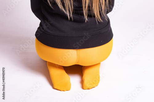 Mädchen in gelber Strumpfhose und roten Schuhen
