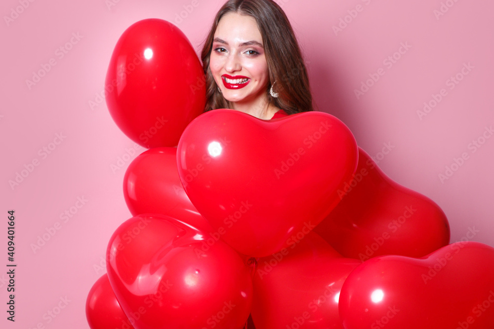 Woman on Valentines Day. Beautiful elegant young woman with heart shape red air balloons on pink background. Woman on Valentines Day. Beautiful elegant young woman with heart shape red air balloons on pink background.