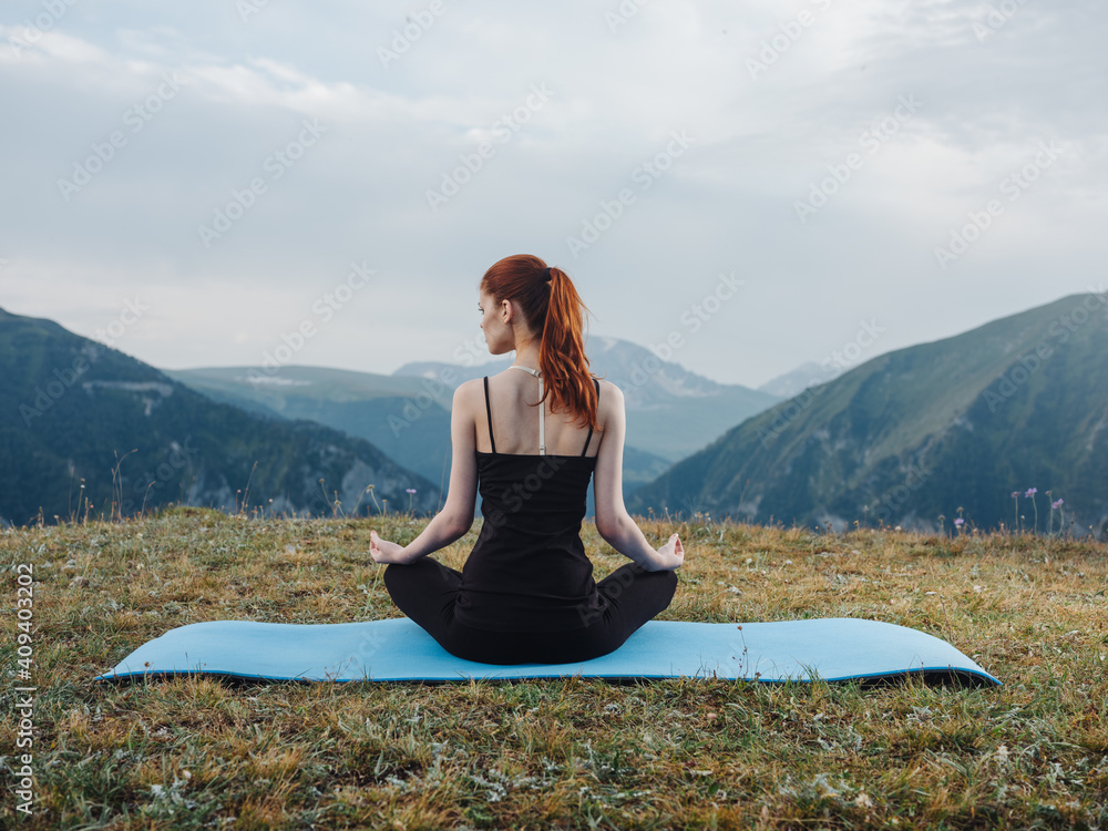 Woman sitting on a mat meditation yoga asana nature fresh air
