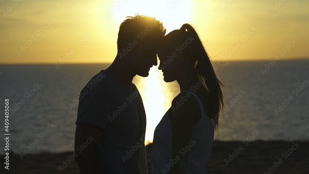 The romantic couple standing on the sea sunset
