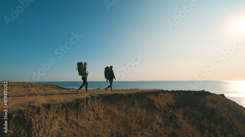 The hiker couple walking on a mountain against the beautiful sea view