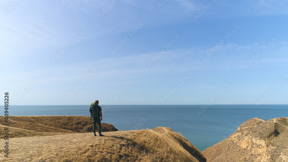 The man standing on the mountain against the beautiful sea view