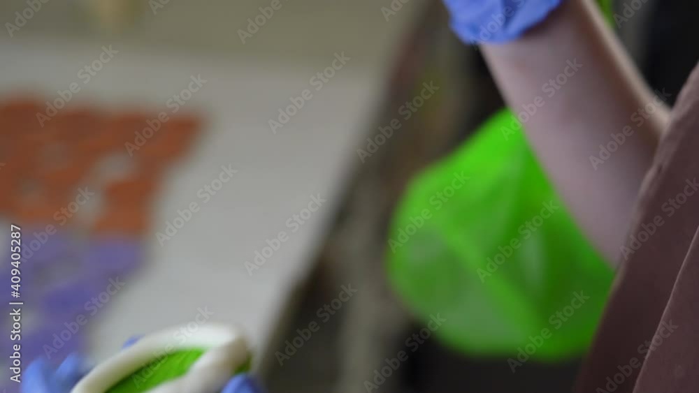 Filling French pasta with purple cream. closeup female hands in gloves Filling French pasta with purple cream. closeup female hands in gloves