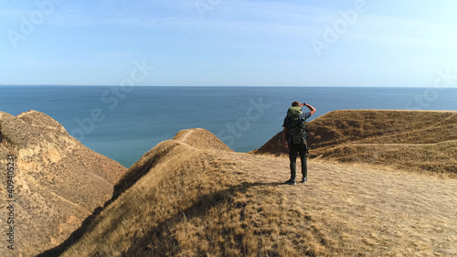 The hiker standing on the mountain against the beautiful sea view