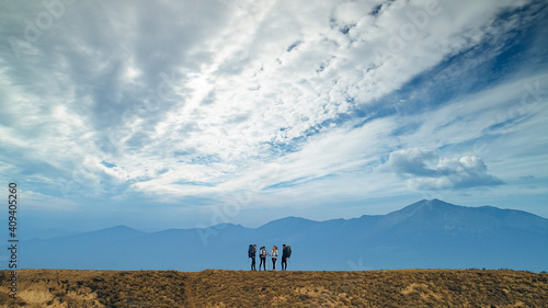 The group of hikers standing on mountains background