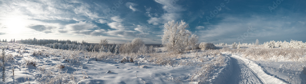 Snowy road at winter Stone Hill park in frosty sunny evening. Winter country road with fir forest in the rays of cold winter Sun. Snowy road at winter Stone Hill park in frosty sunny evening. Winter country road with fir forest in the rays of cold winter Sun.