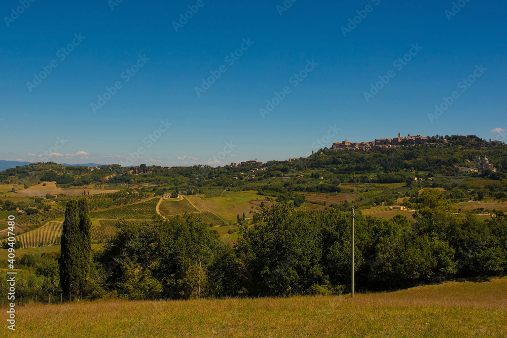 Obraz premium The late summer landscape around Montepulciano in Val d'Orcia, Siena Province, Tuscany, Italy. Montepulciano can be seen in the background right