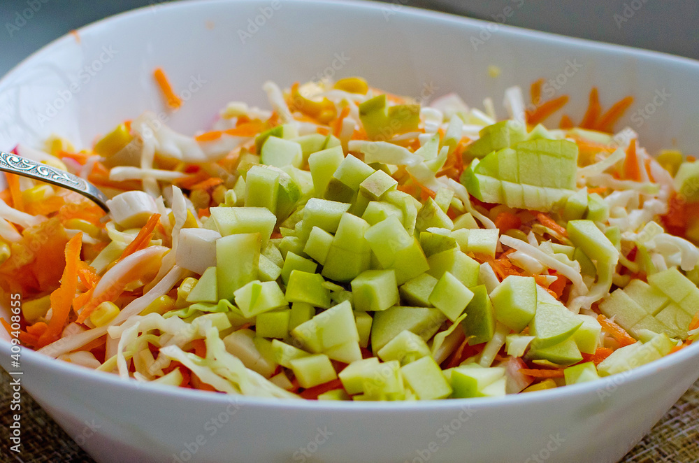 Fresh salad with cabbage, carrots and apple, close-up. Healthy food.