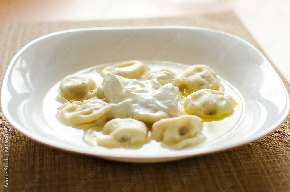 dumplings on a table with butter and sour cream. Close-up photo. dumplings on a table with butter and sour cream. Close-up photo.