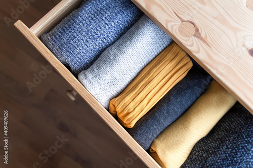 Fotografering Open wooden dresser drawer with warm knitted woolen clothes