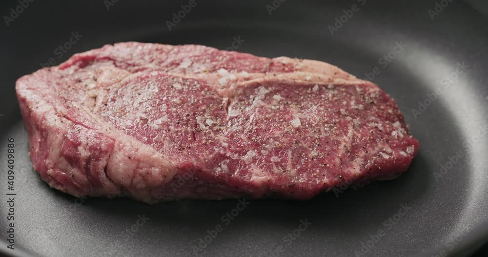 Closeup shot of ribeye steak frying on non stick pan Closeup shot of ribeye steak frying on non stick pan