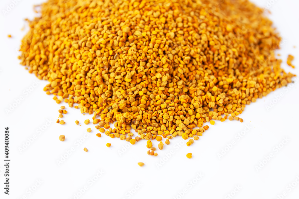 Crumbled bee pollen granules on white background. Crumbled bee pollen granules on white background.