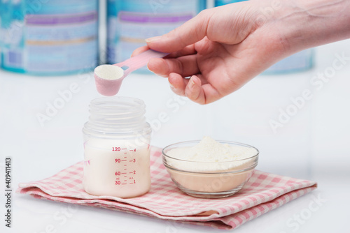 Preparation of mixture baby feeding on white table background