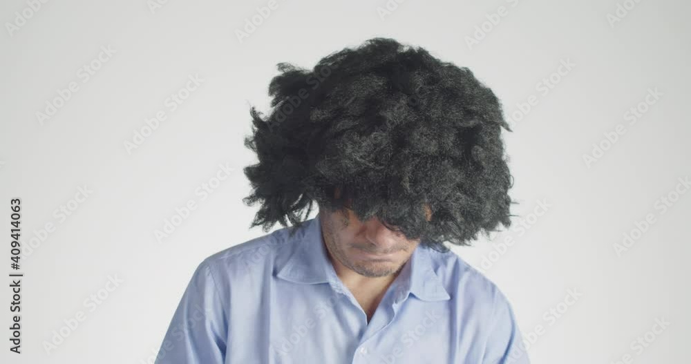 Front view of a curly-haired tries unlikely sunglasses isolated on gray background. Front view of a curly-haired tries unlikely sunglasses isolated on gray background.