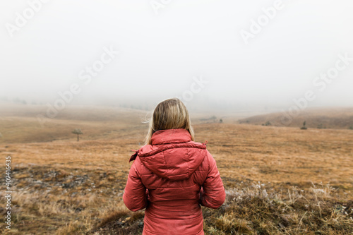 Young woman exploring nature in the foggy winter morning