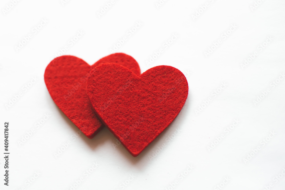 Red felt hearts on a white background. Valentine's Day