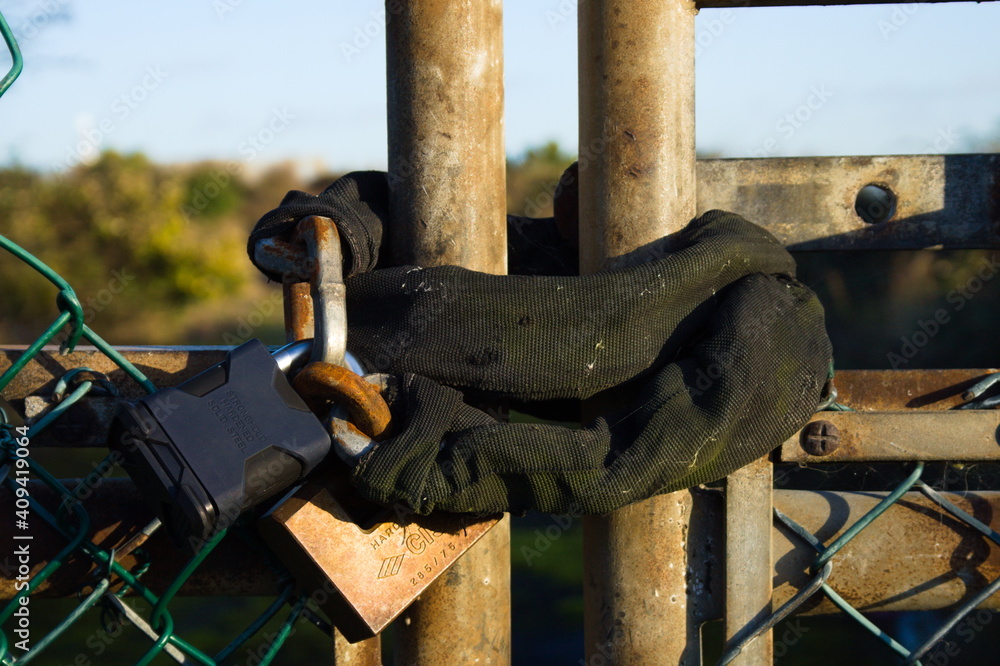 Old padlock on rusty shabby gate close up 