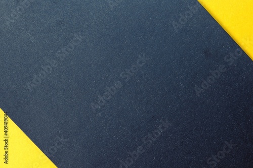Gray paper background with yellow triangular inserts in the corners. Copy space.