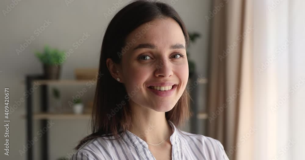 Head shot close up happy attractive young 25s woman looking at camera, showing perfect smile with white teeth, feeling peaceful indoors. Millennial generation beautiful lady posing in own house. Head shot close up happy attractive young 25s woman looking at camera, showing perfect smile with white teeth, feeling peaceful indoors. Millennial generation beautiful lady posing in own house.