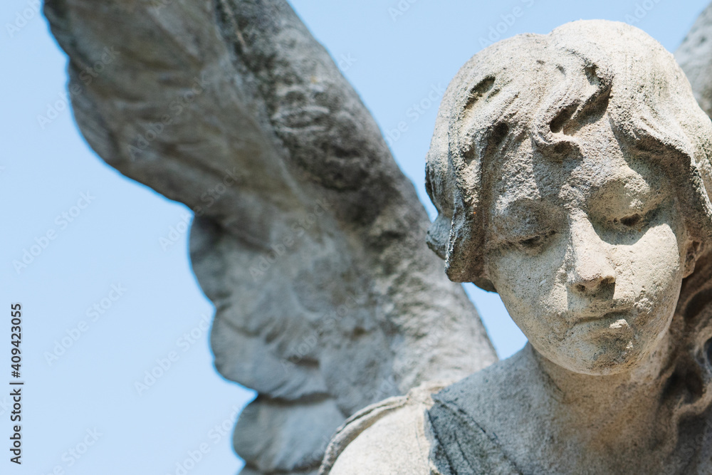 Beautiful angel as symbol of death and the end of human life. Fragment of an antique stone statue.