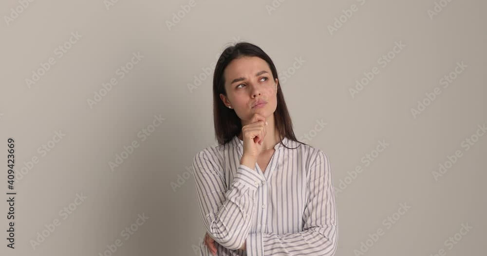 Pensive puzzled young businesswoman touching chin, looking up in distance, thinking of problem solution or pondering difficult decision, feeling doubtful isolated on white wall or studio background. Pensive puzzled young businesswoman touching chin, looking up in distance, thinking of problem solution or pondering difficult decision, feeling doubtful isolated on white wall or studio background.
