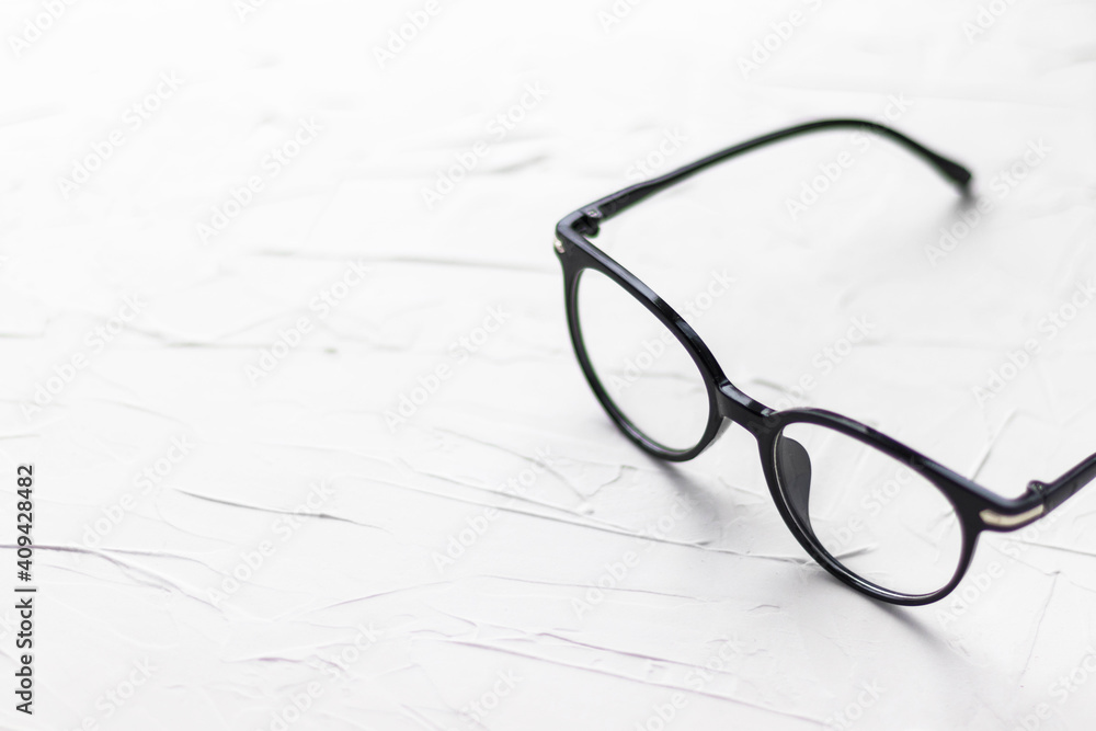 Eyeglasses with black frame on white background. Eye glasses. Round glasses with transparent lenses. Close up eyeglasses with blurry technique. Fashion accessory. Ophthalmology theme. Eyeglasses with black frame on white background. Eye glasses. Round glasses with transparent lenses. Close up eyeglasses with blurry technique. Fashion accessory. Ophthalmology theme.