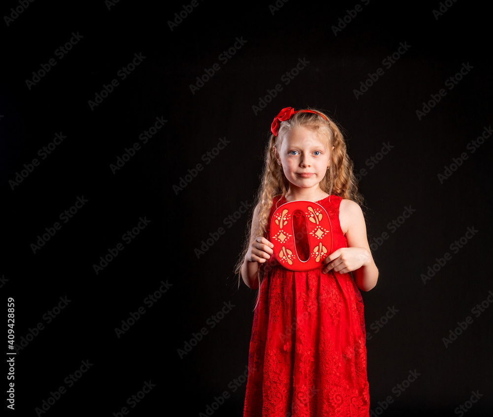 O holds a child holding in his hand the letter LOVE Valentine Valentine's background, , on the floor hearts a lovely layout. form a holiday. forever, joy in a red girl dress, barefoot O holds a child holding in his hand the letter LOVE Valentine Valentine's background, , on the floor hearts a lovely layout. form a holiday. forever, joy in a red girl dress, barefoot