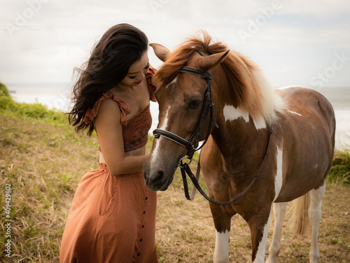 Asian woman cuddling her horse. Horse riding. Human and animals relationship. Nature concept. Bali