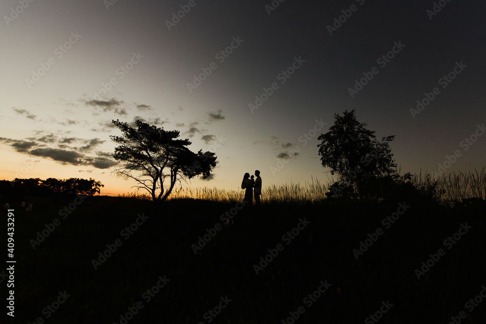 Silhouette of parents and a small child at sunset.