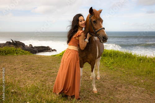 Woman hugging brown horse. Romantic concept. Love to animals. Nature concept. Bali