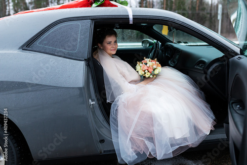 Photo the groom gives his hand to the bride from the car, the politeness and gallantry
