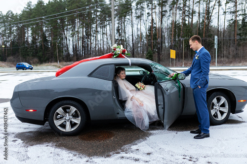 Fotografía the groom gives his hand to the bride from the car, the politeness and gallantry