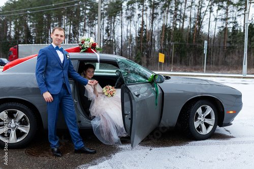Foto the groom gives his hand to the bride from the car, the politeness and gallantry