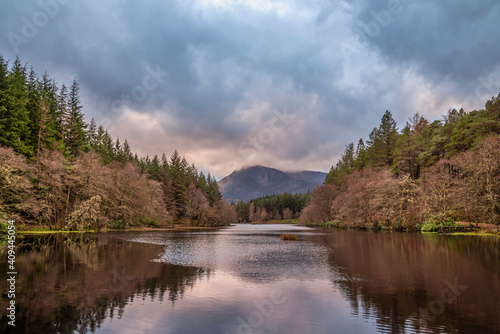 Stunning landscape image of Glencoe Lochan with Pap of Glencoe in the distance on a Winter s evening