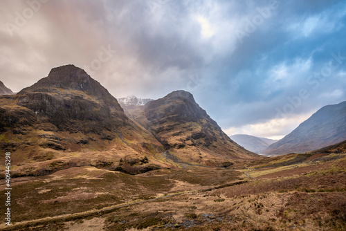 Majestic moody landscape image of Three Sisters in Glencoe in Scottish Highlands on a wet Winter day wit high water running down mountains photo