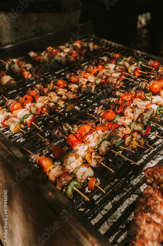 shrimp and vegetable skewers on a black grill.