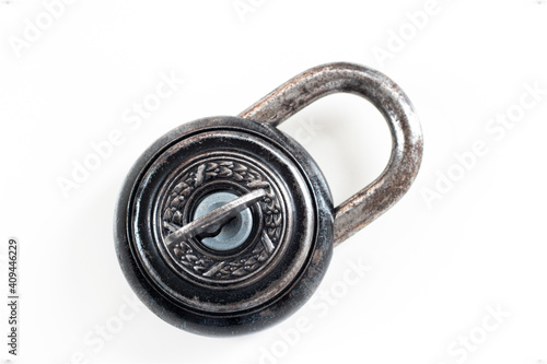 Corroded Old vintage lock with beautiful metalwork decoration isolated on white with key inside hole