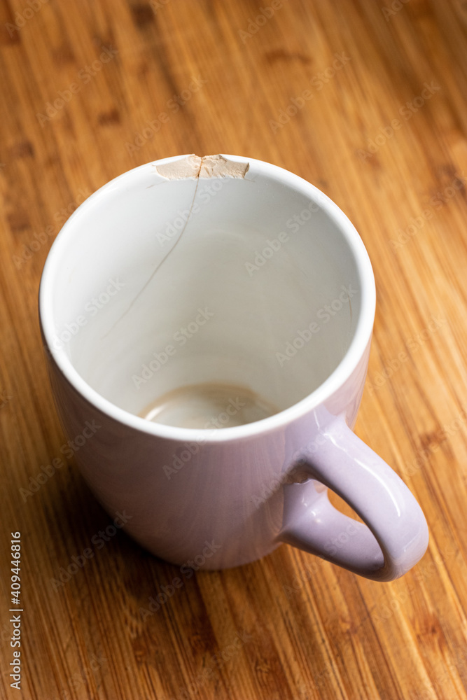 Chipped ceramic cup macro close up shot in the kitchen