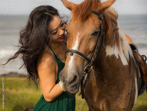 Portrait of woman and brown horse. Asian woman cuddling horse. Romantic concept. Love to animals. Nature concept. Bali